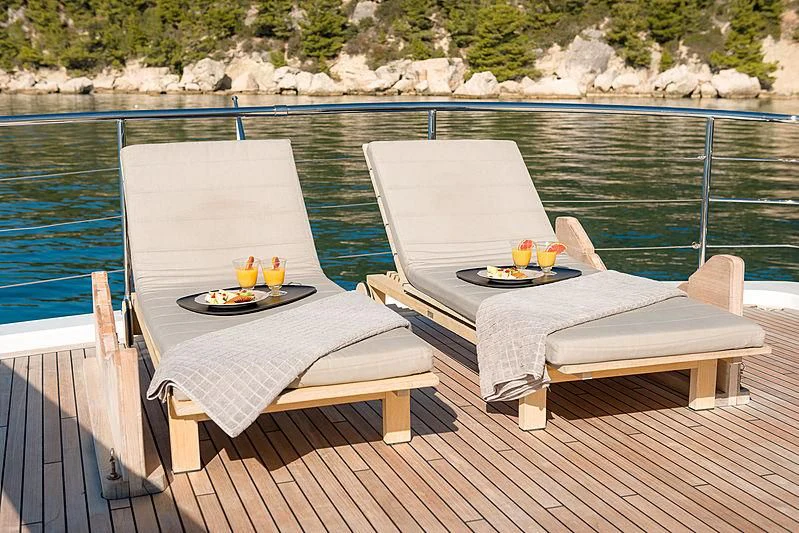 a table on a deck overlooking a body of water aboard MOONRAKER II Yacht for Sale