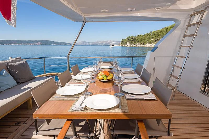 a table with plates and glasses on it aboard MOONRAKER II Yacht for Sale