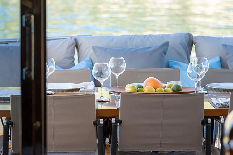 a table with wine glasses on it aboard MOONRAKER II Yacht for Sale
