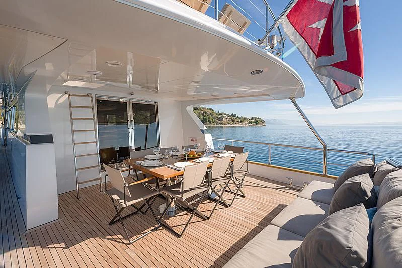 a room with a table and chairs and a large body of water aboard MOONRAKER II Yacht for Sale