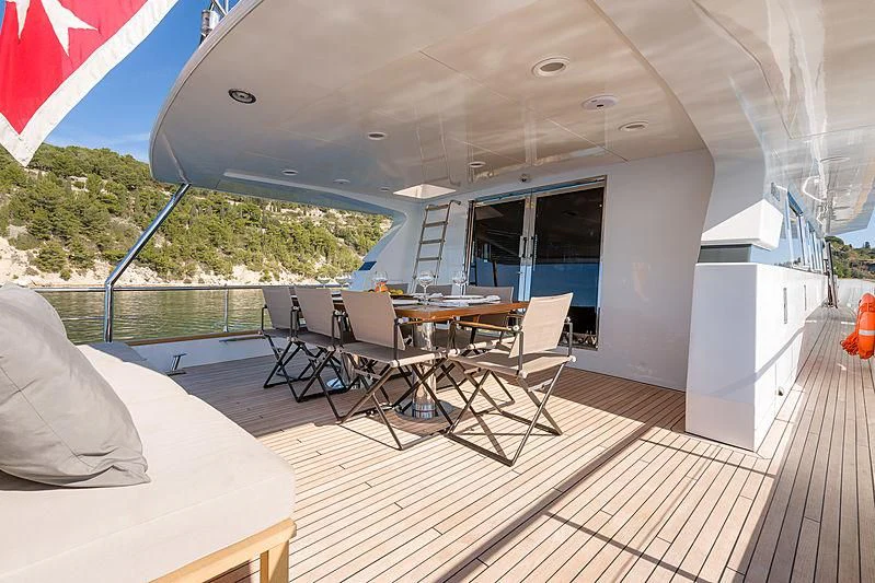 a deck with a table and chairs aboard MOONRAKER II Yacht for Sale