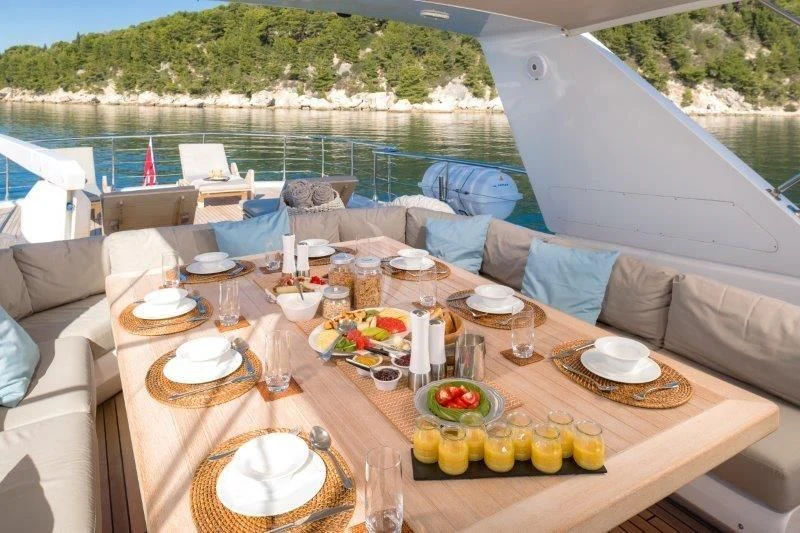 a table with plates and food on it aboard MOONRAKER II Yacht for Sale