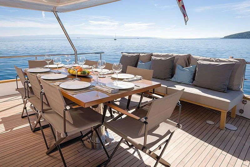 a table with chairs on it next to a large body of water aboard MOONRAKER II Yacht for Sale