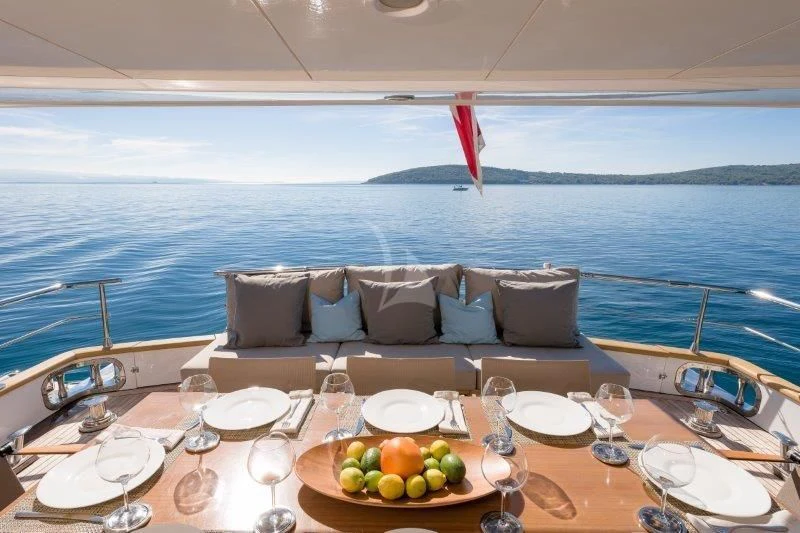 a table with food and wine glasses on it aboard MOONRAKER II Yacht for Sale