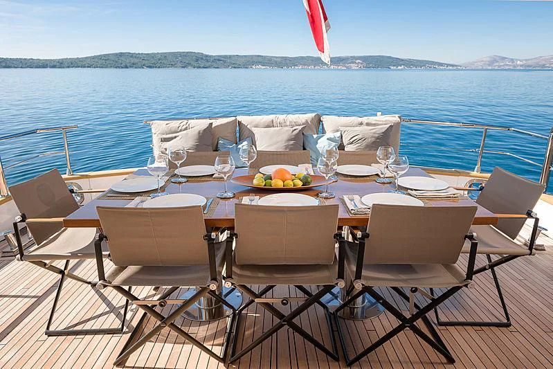 a table set for a dinner on a beach aboard MOONRAKER II Yacht for Sale