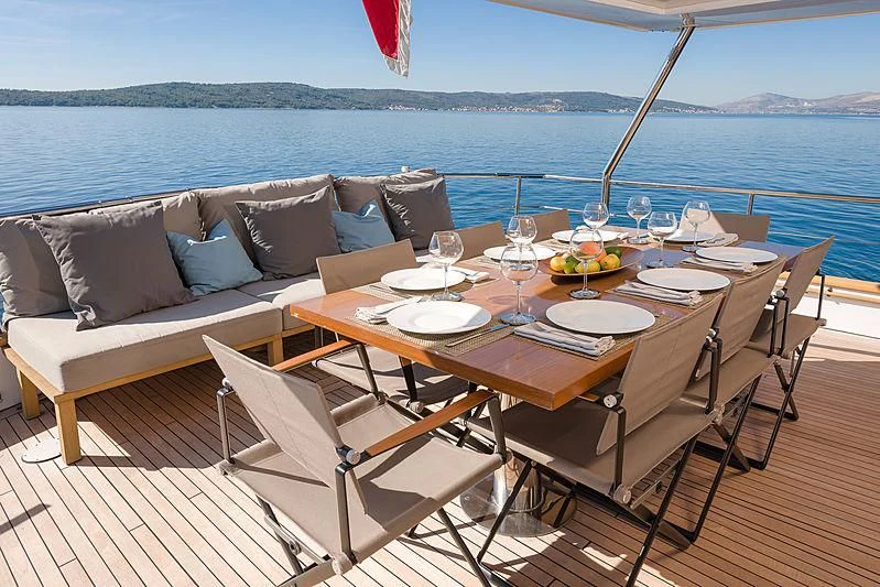 a table set for a meal on a deck overlooking the ocean aboard MOONRAKER II Yacht for Sale