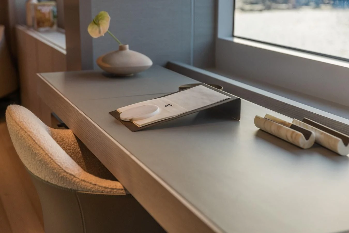 a desk with a laptop and a flower on it aboard FAMILIA Yacht for Sale