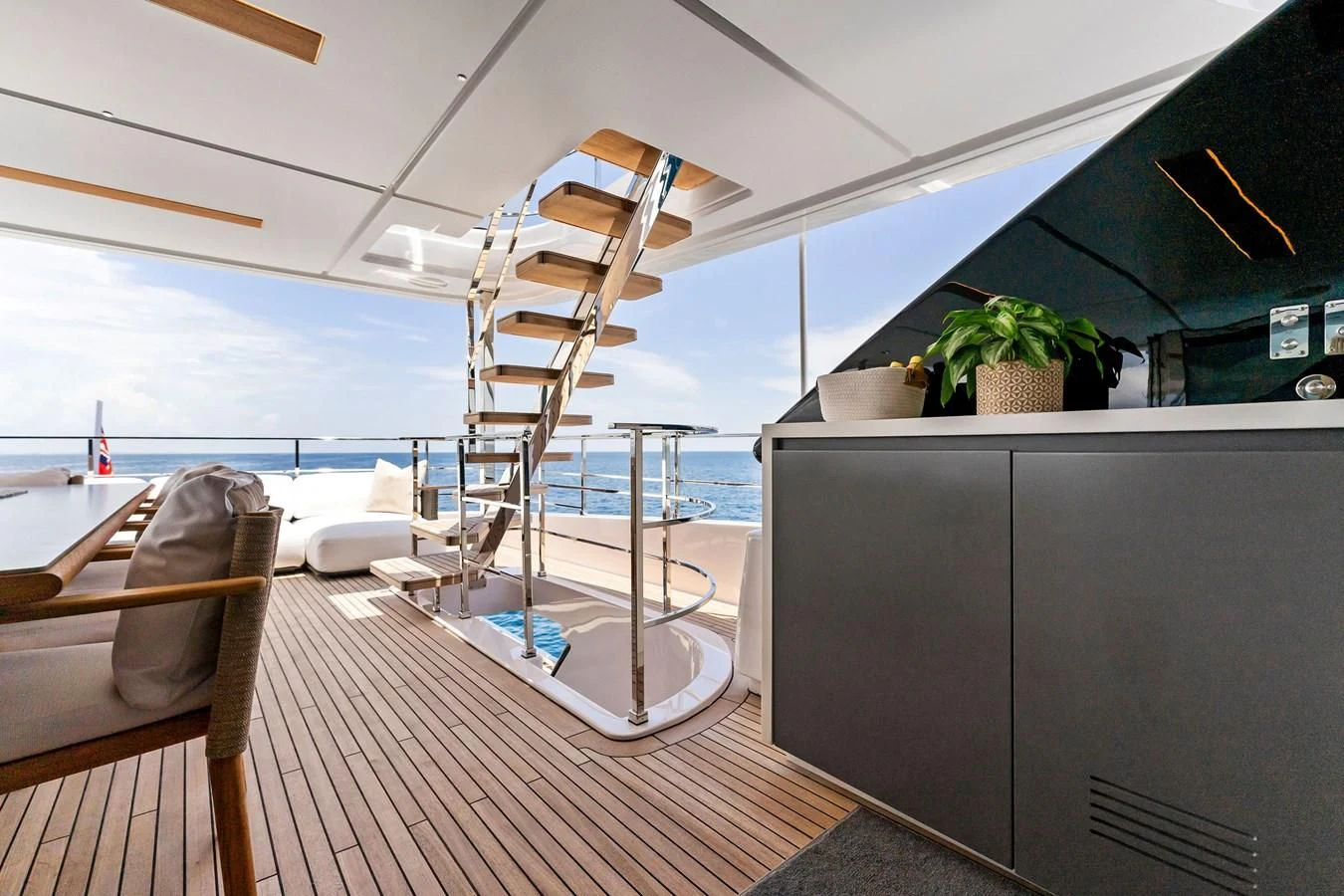 a room with a wood floor and a railing and a railing with a view of the ocean and aboard FAMILIA Yacht for Sale