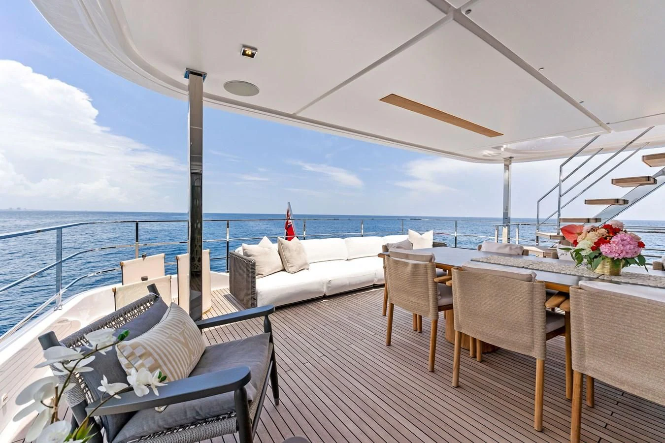 a balcony with a table and chairs on the deck aboard FAMILIA Yacht for Sale
