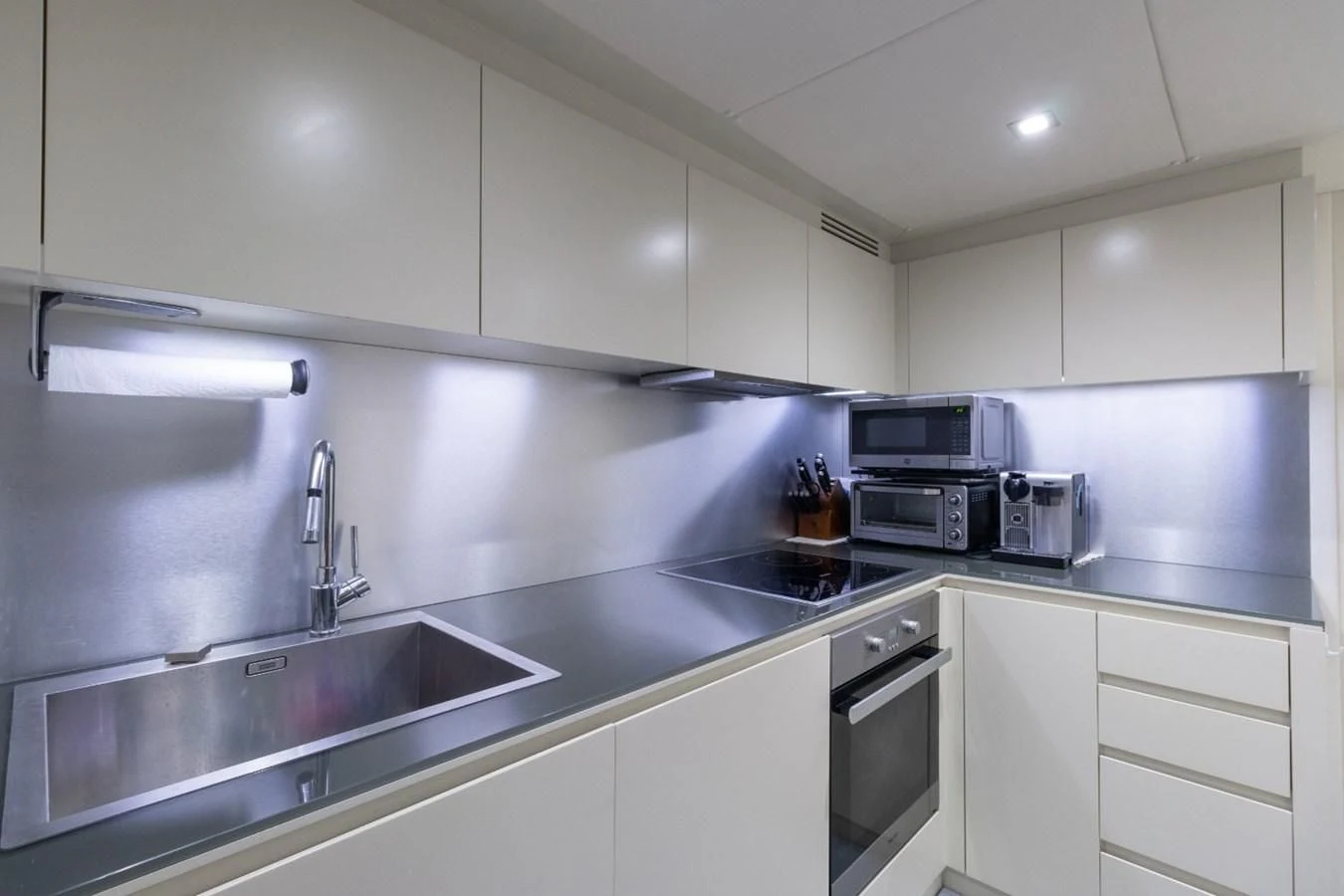 a kitchen with white cabinets aboard SUGAR Yacht for Sale