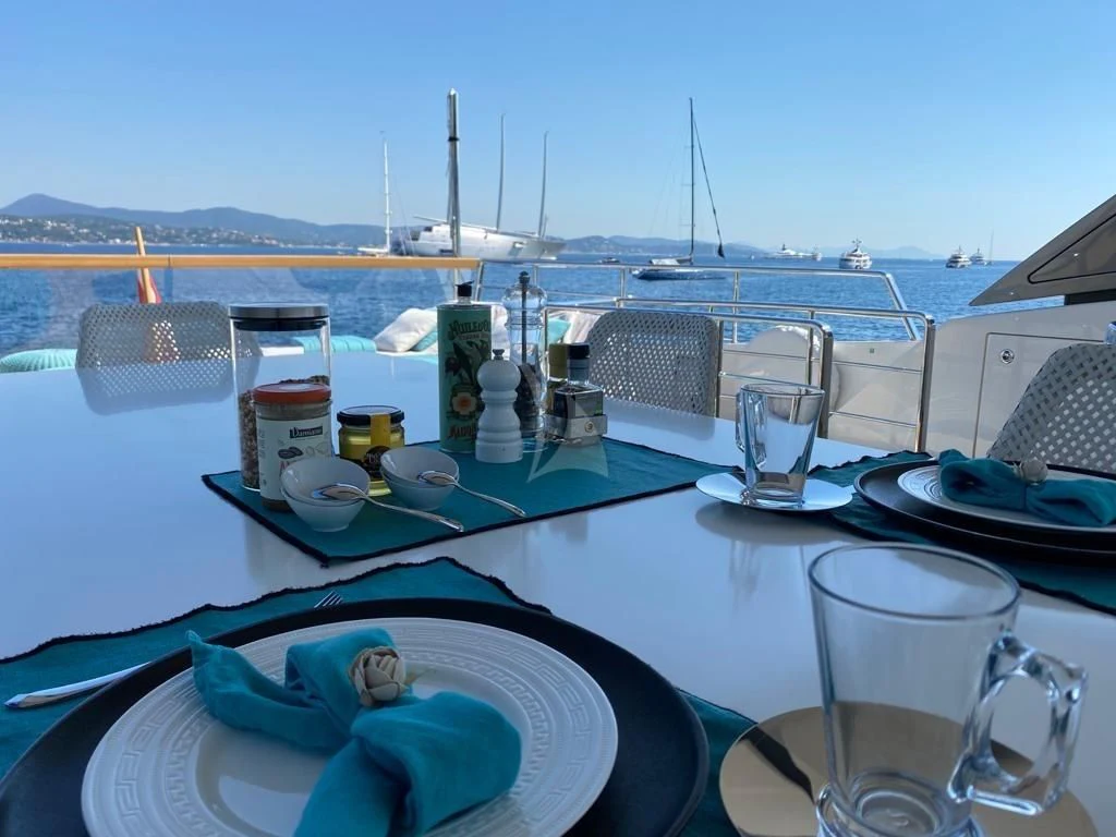 a table with plates and cups on it aboard DE ZEUS Yacht for Sale