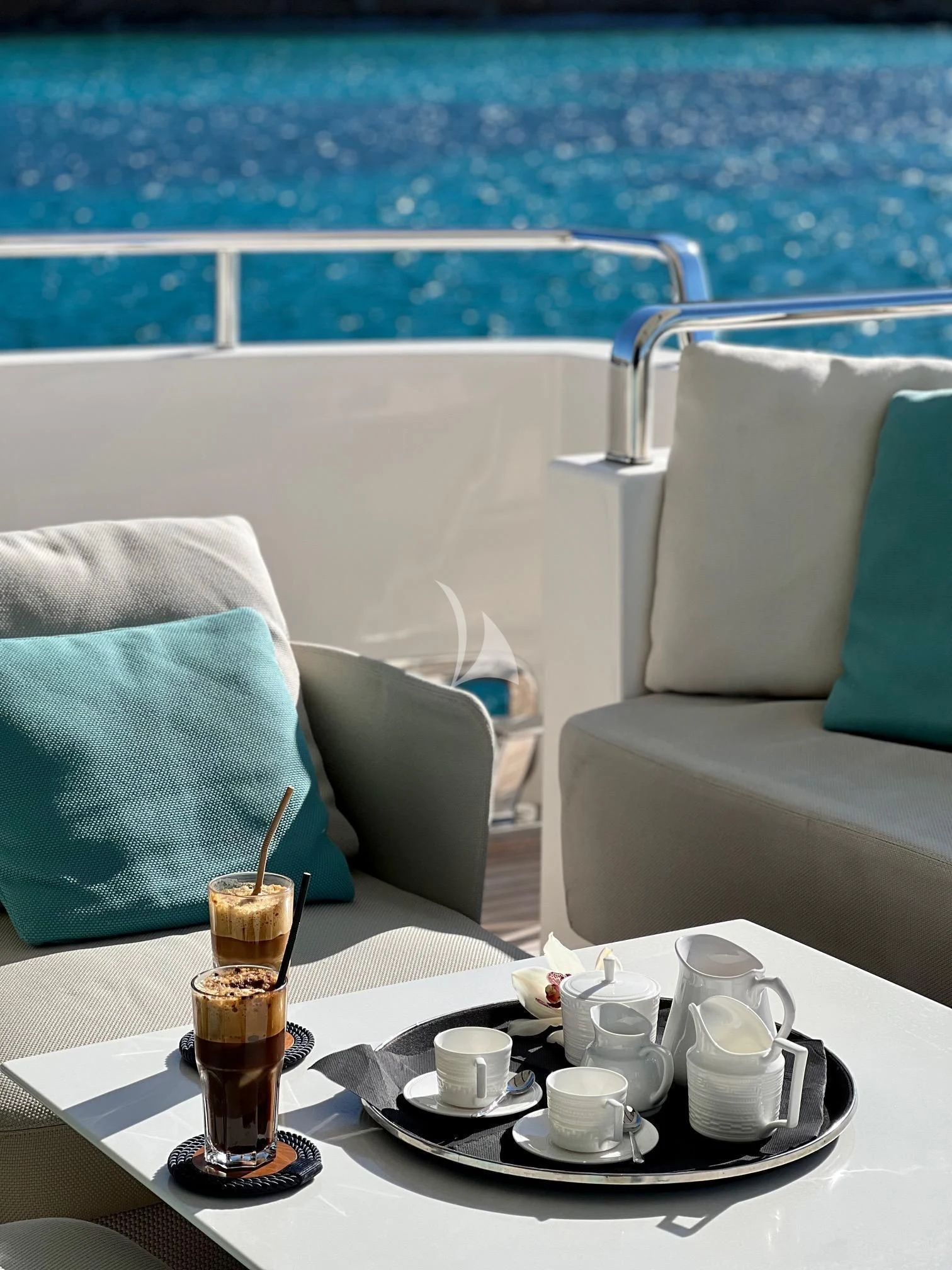 a glass of beer on a table with a glass of beer and a view of the water aboard DE ZEUS Yacht for Sale