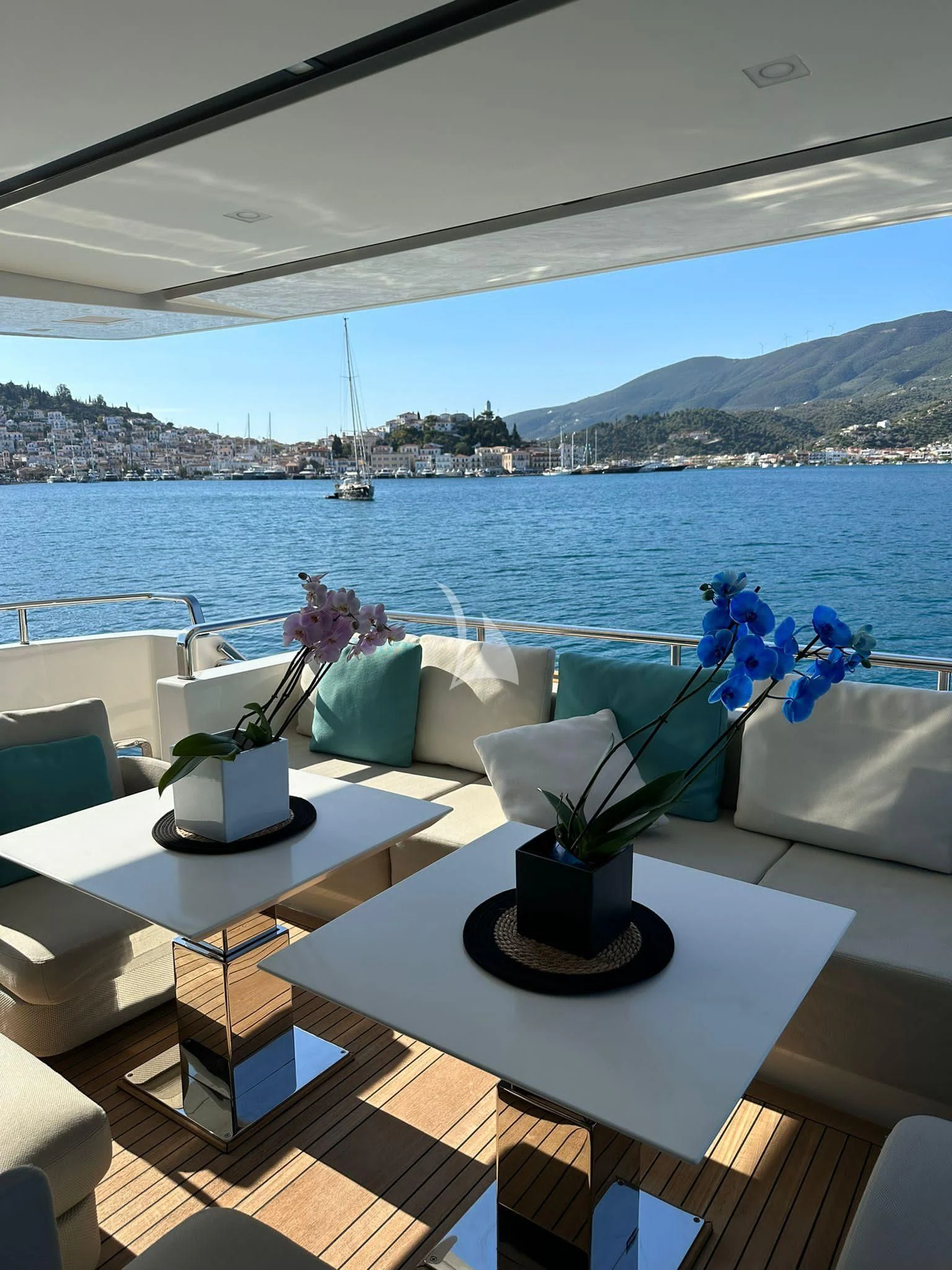 a table with flowers on it by a window with a view of a city and water aboard DE ZEUS Yacht for Sale