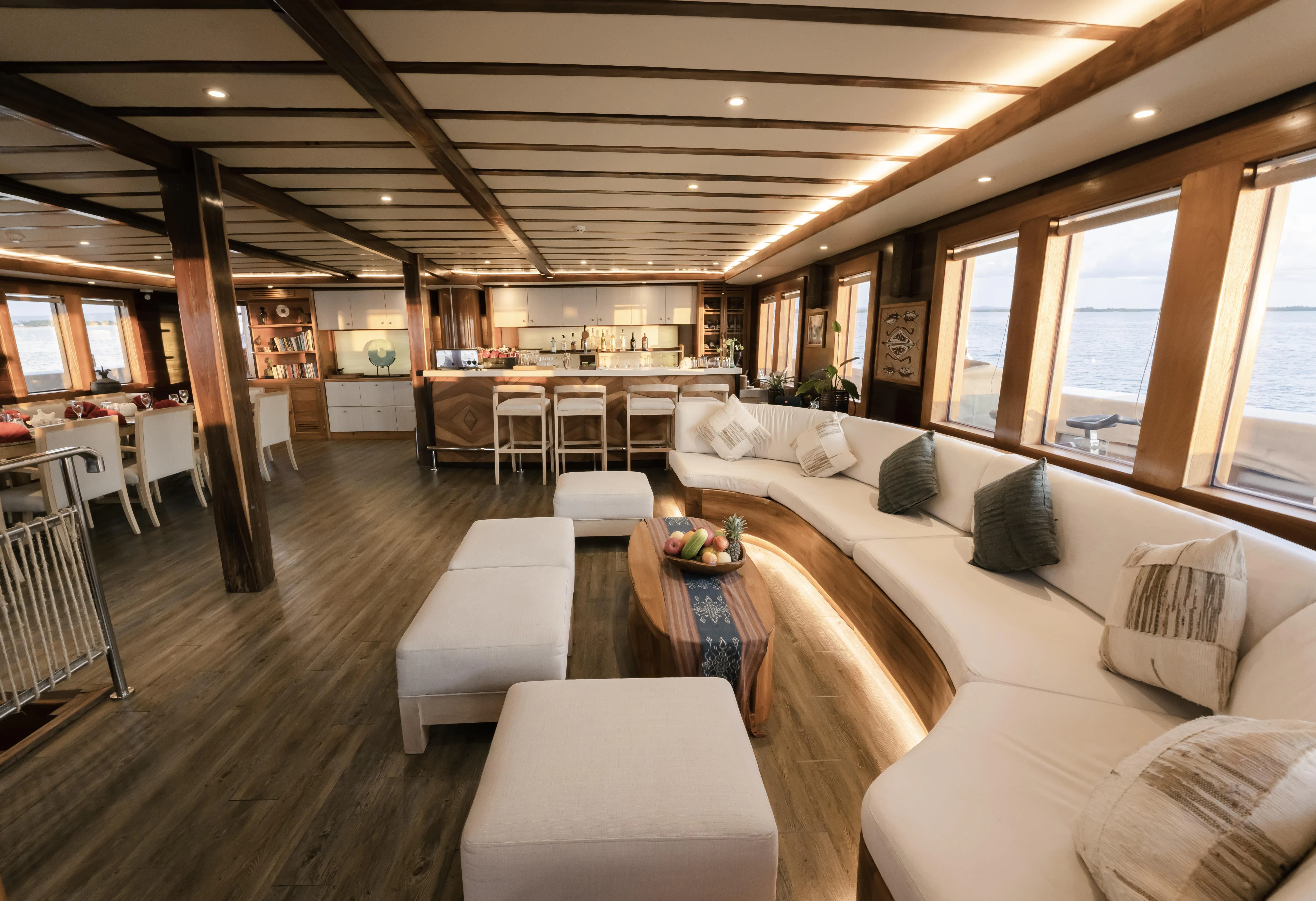 a living room with a couch and a table aboard LAMIMA Yacht for Sale