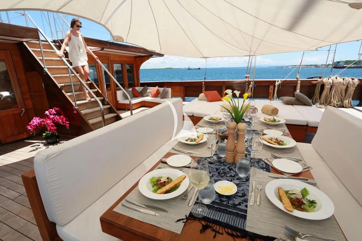 a table with plates and food on it aboard LAMIMA Yacht for Sale