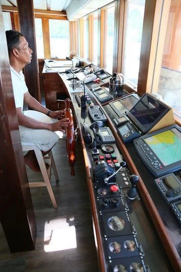 a person sitting in a chair in a room with electronic equipment aboard LAMIMA Yacht for Sale