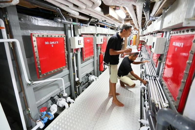 a person in a room with a large red sign and a person in a black shirt holding a aboard LAMIMA Yacht for Sale