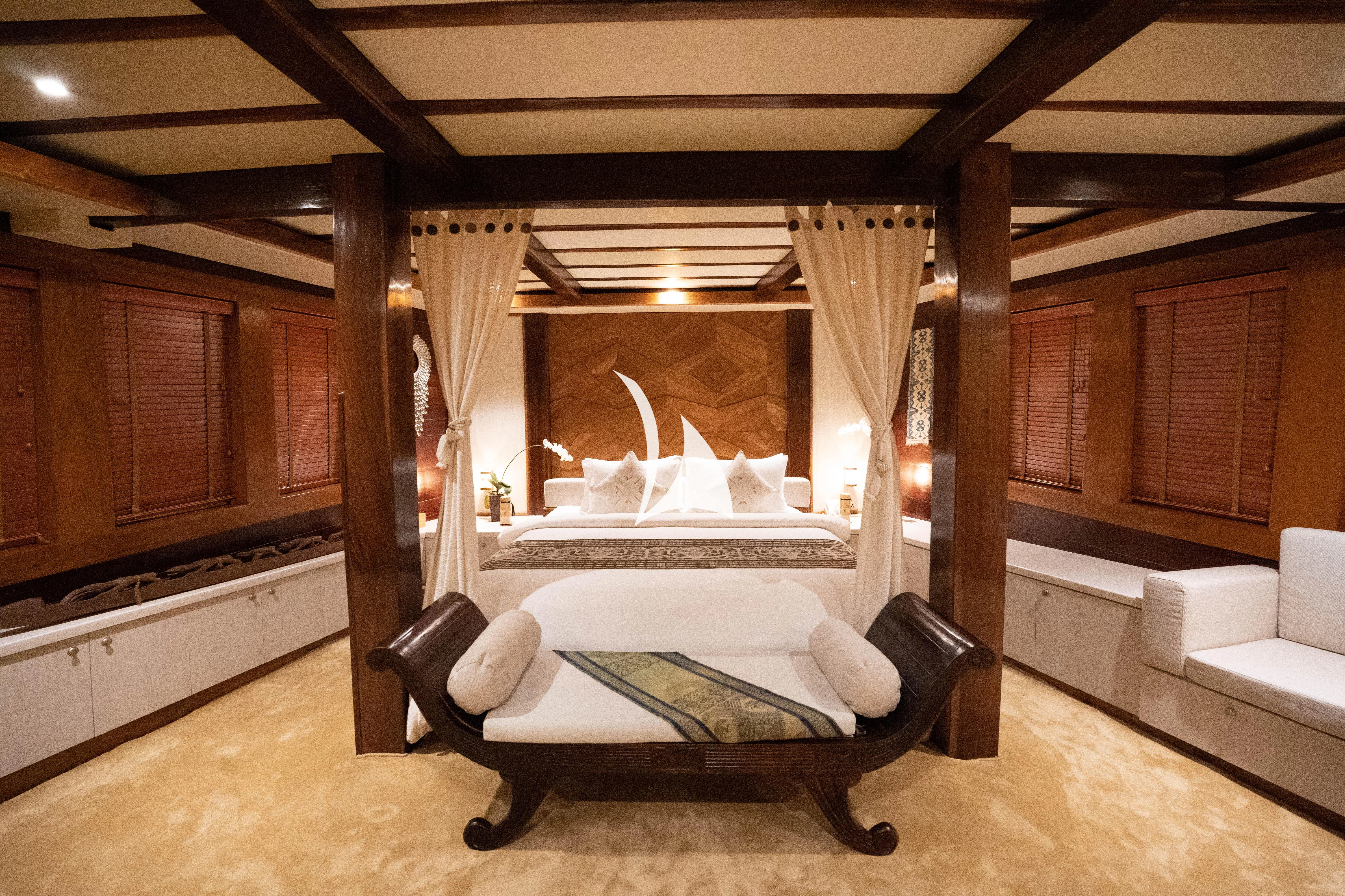 a room with a bed and a fireplace aboard LAMIMA Yacht for Sale