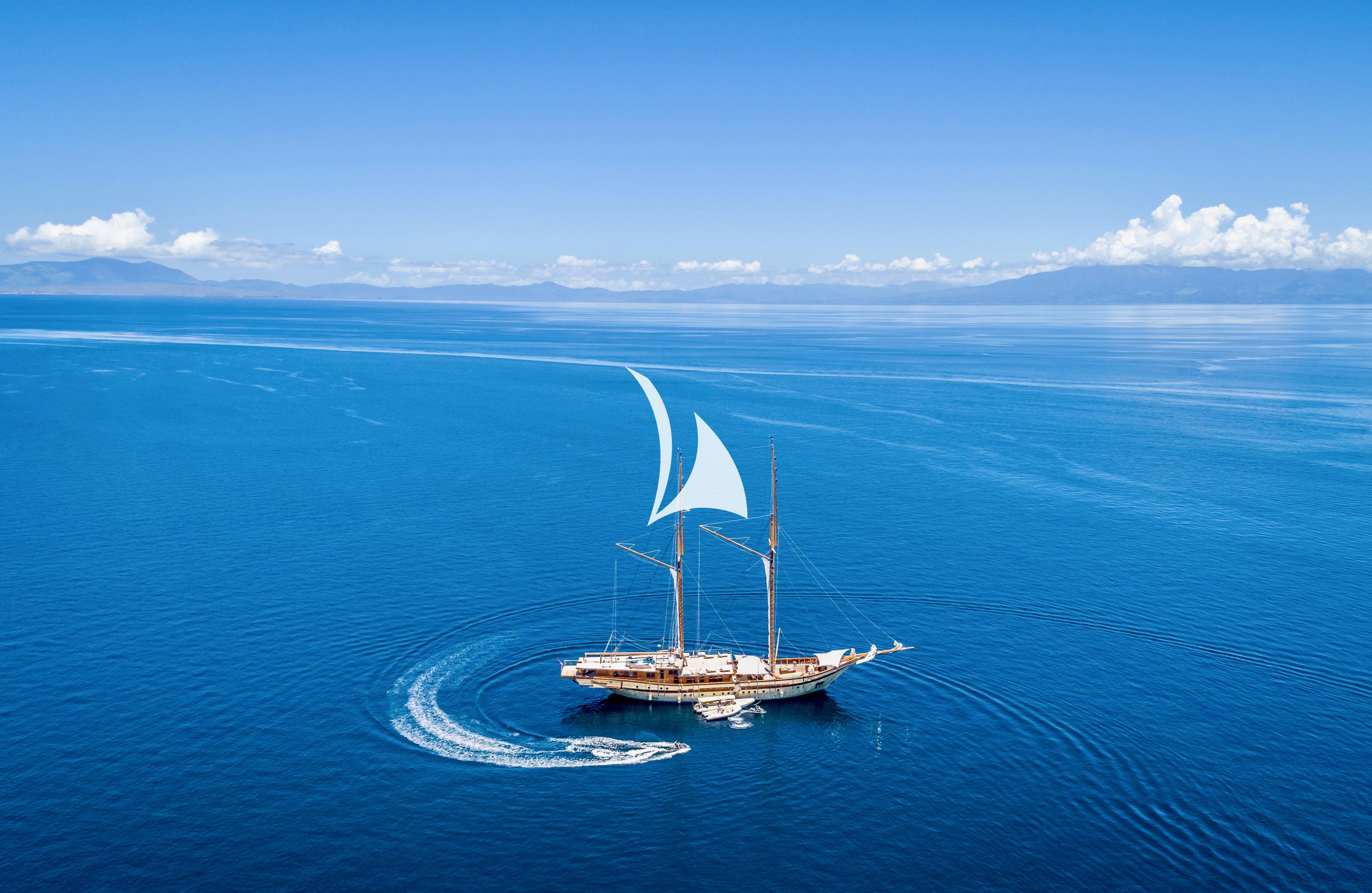 a small sailboat in the ocean aboard LAMIMA Yacht for Sale