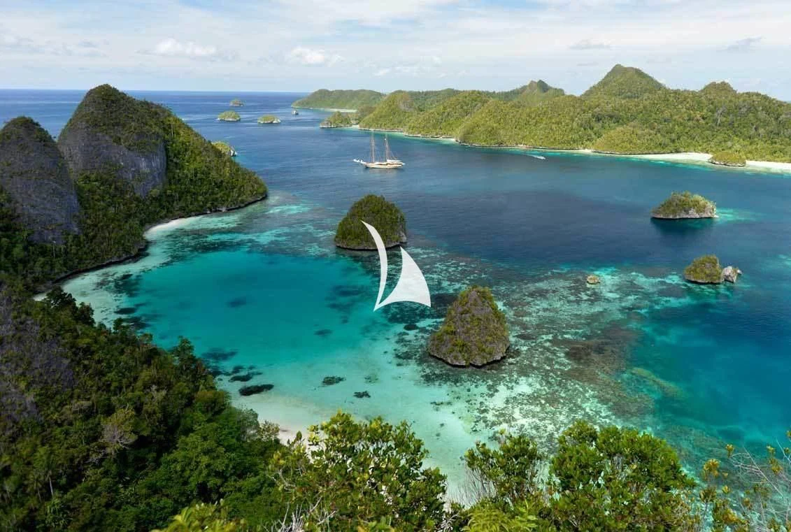 a small island with a sailboat aboard LAMIMA Yacht for Sale