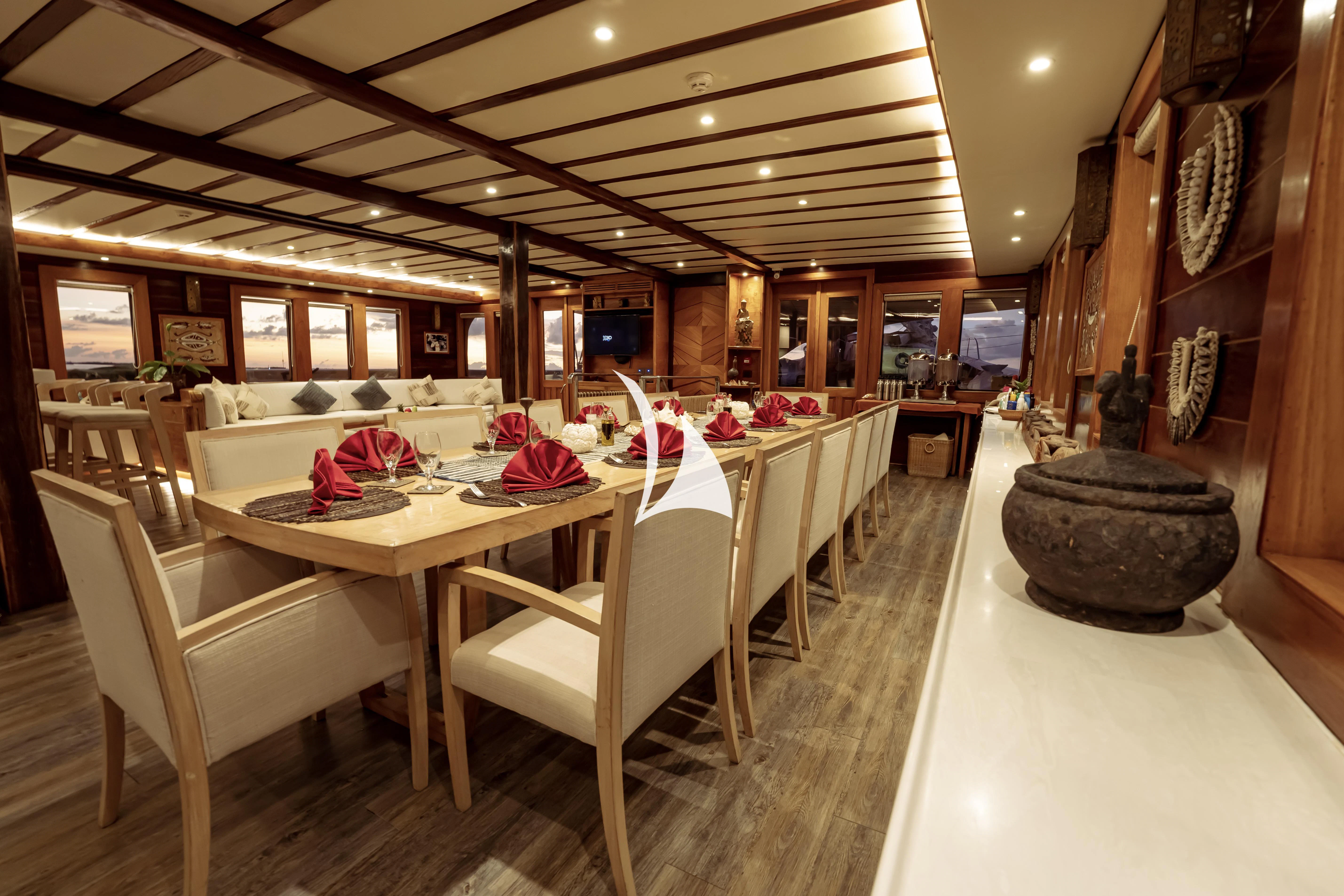 a large room with tables and chairs aboard LAMIMA Yacht for Sale