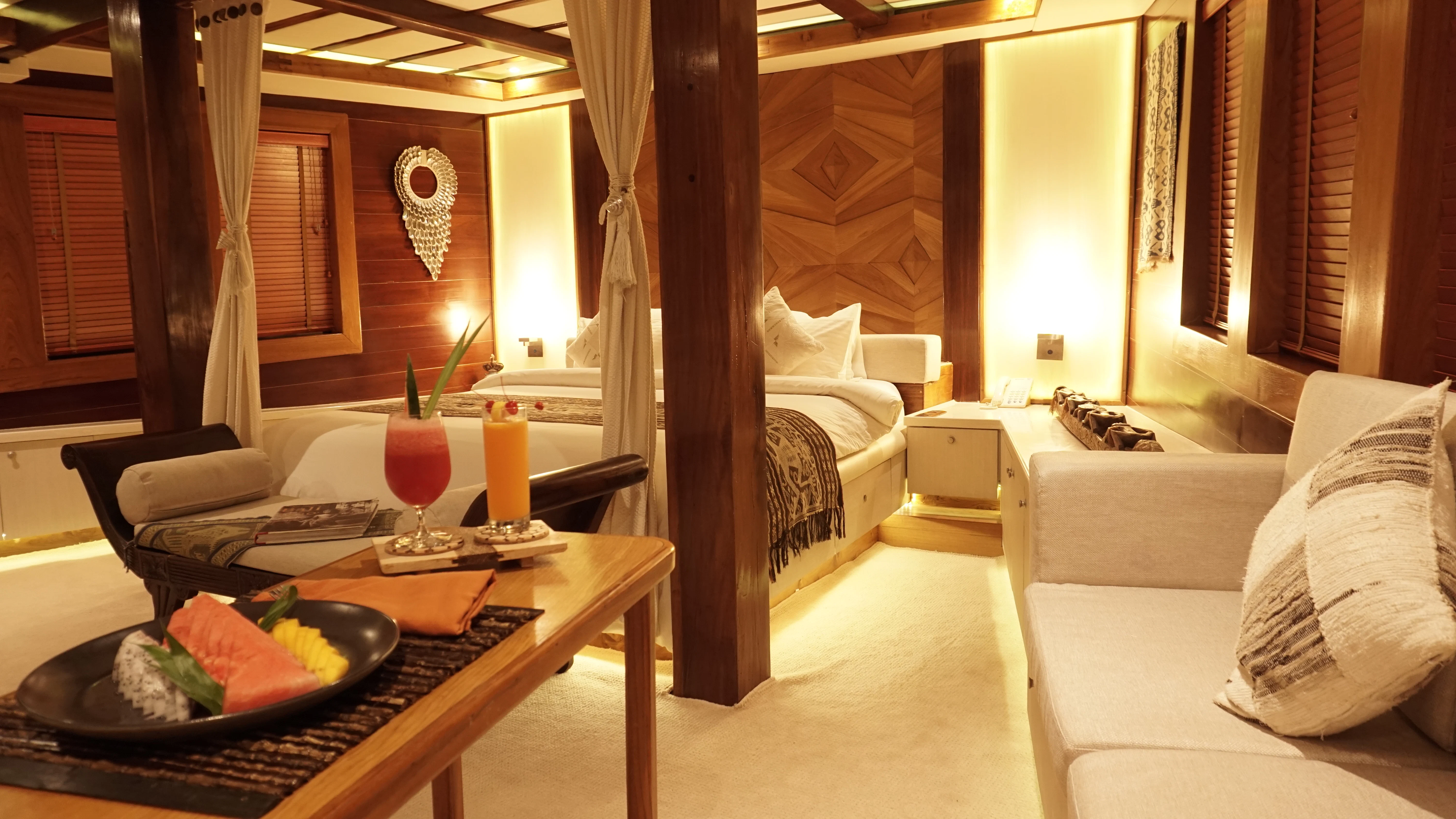 a room with a bed and a table with a plate of food aboard LAMIMA Yacht for Sale