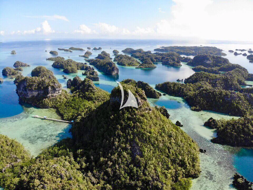 a rocky beach with blue water aboard LAMIMA Yacht for Sale