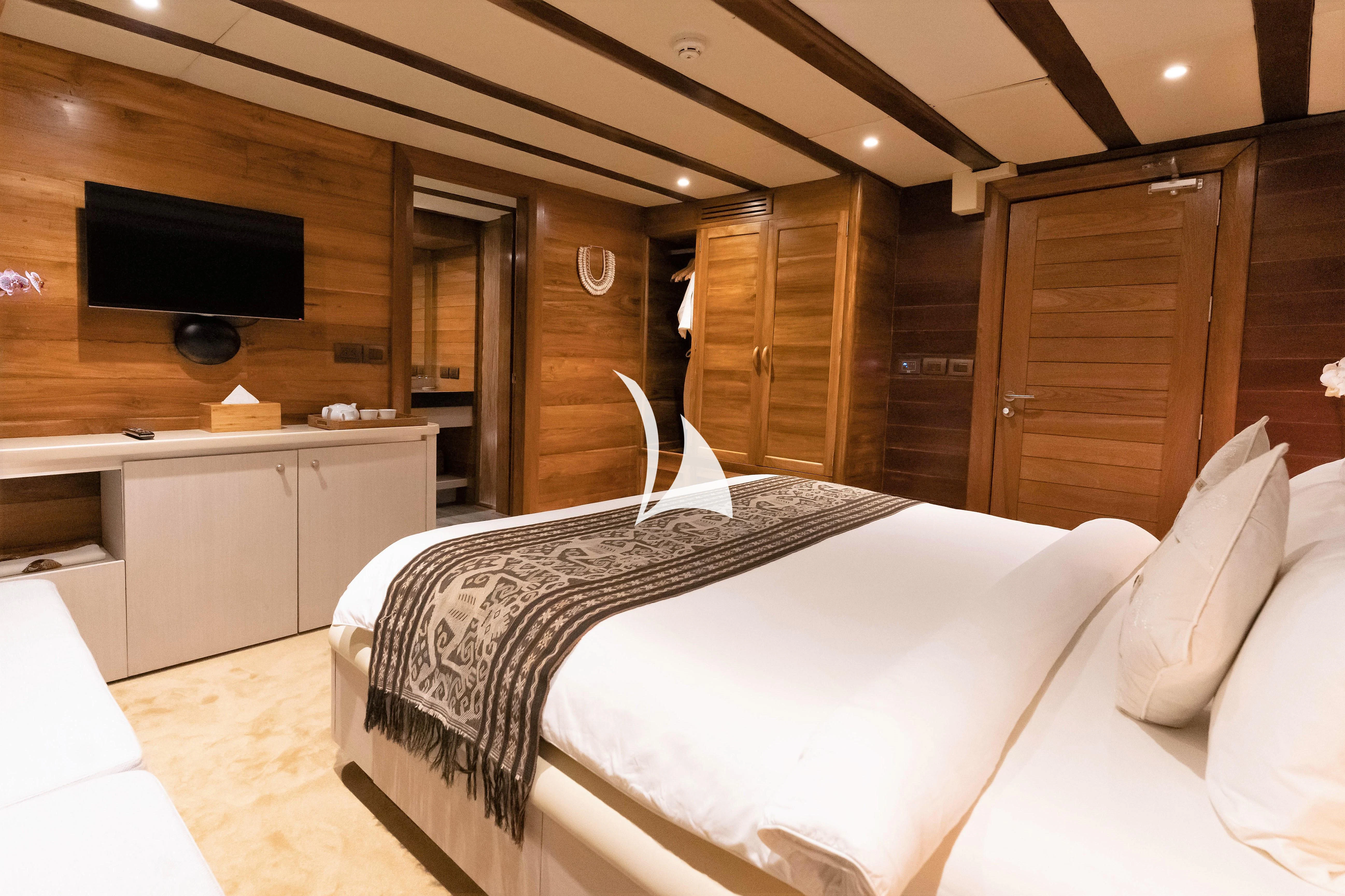 a hotel room with a bed and tv aboard LAMIMA Yacht for Sale