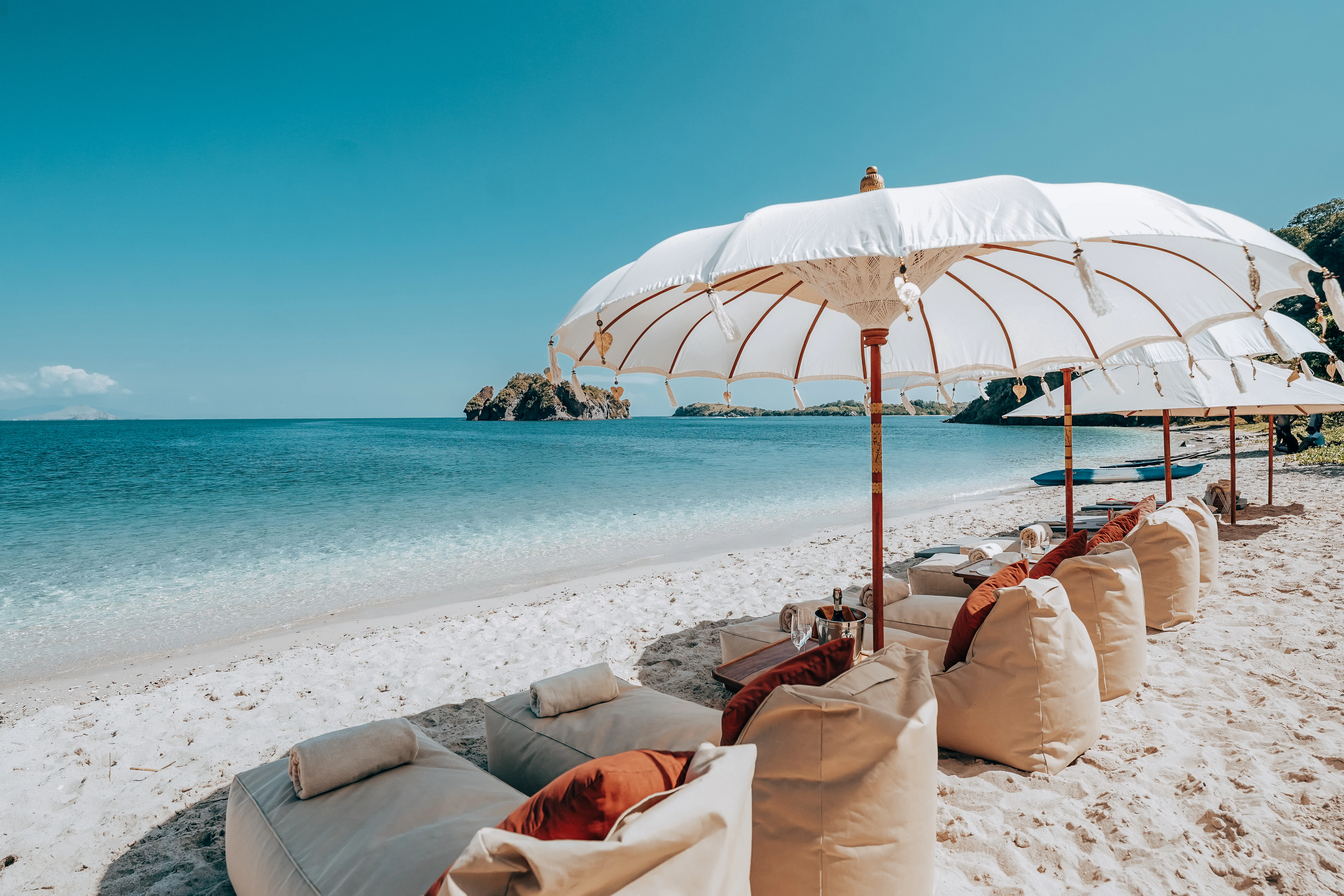 a person lying on a beach under an umbrella aboard LAMIMA Yacht for Sale