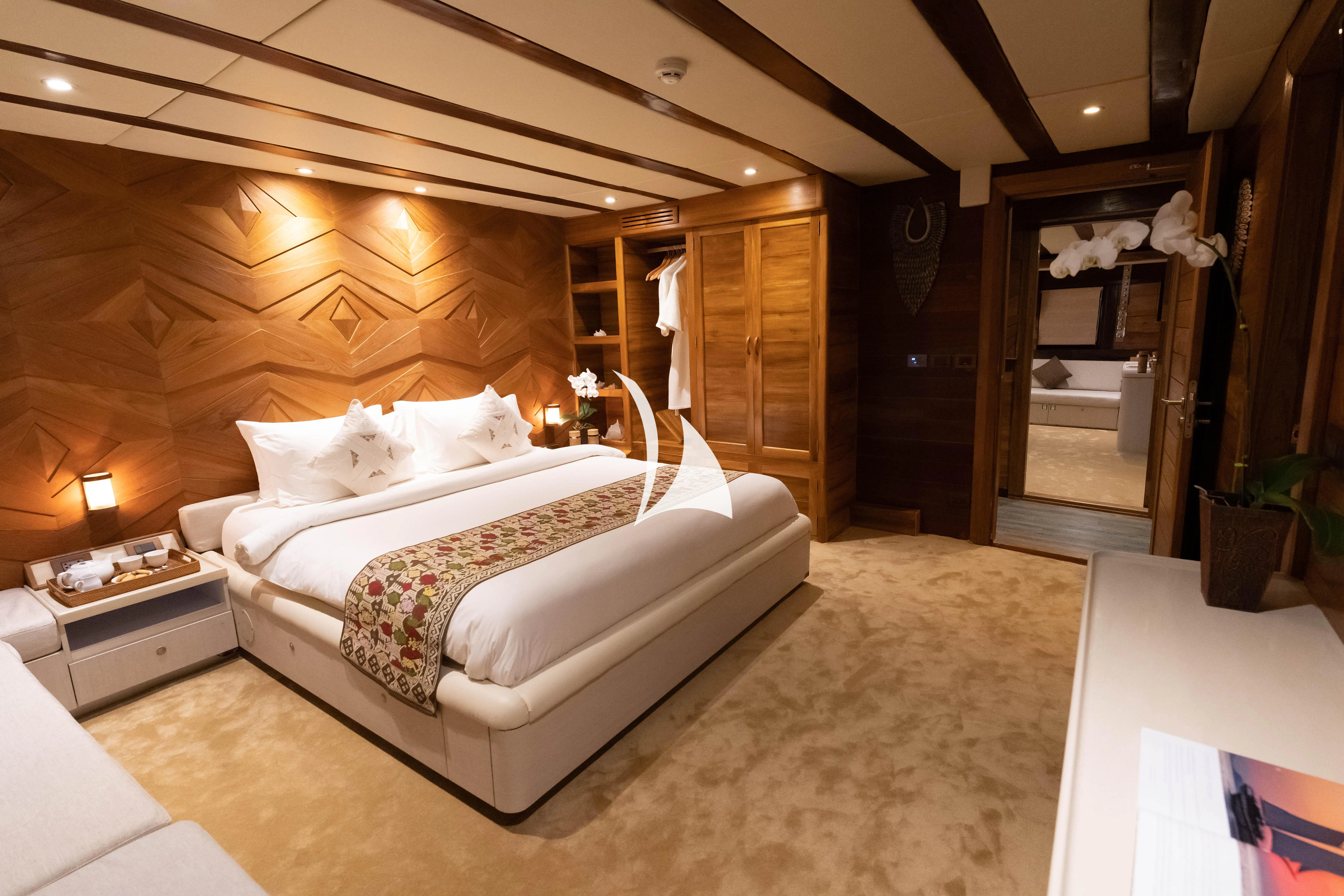 a bedroom with a bed and a wood wall aboard LAMIMA Yacht for Sale