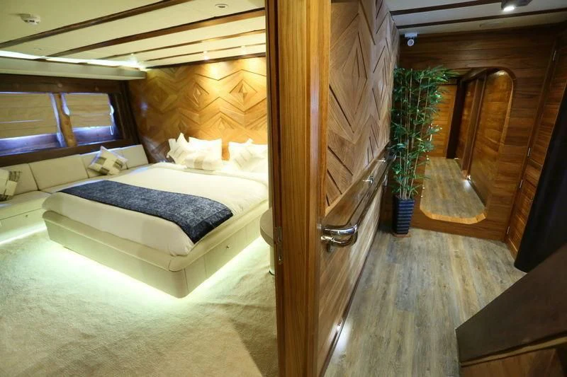 a room with a bed and a table aboard LAMIMA Yacht for Sale