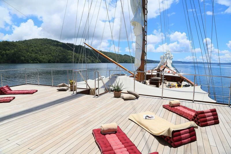 a deck with a table and chairs on it aboard LAMIMA Yacht for Sale
