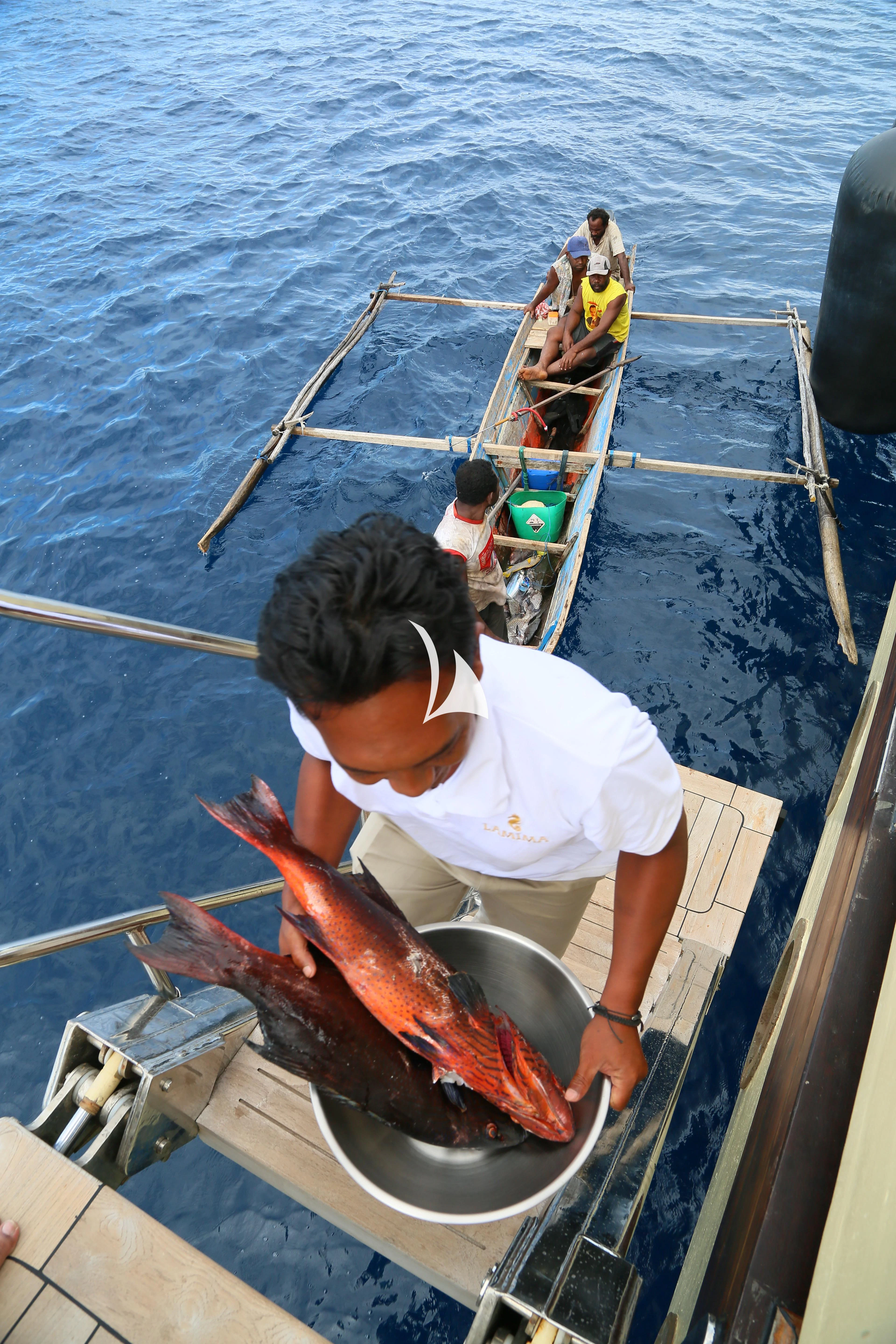 a man in a boat with a fish aboard LAMIMA Yacht for Sale