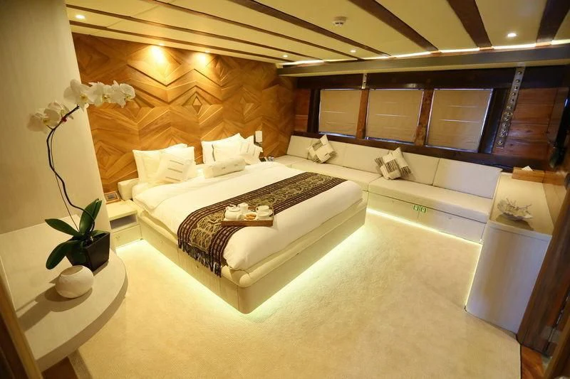 a room with a bed and a plant aboard LAMIMA Yacht for Sale