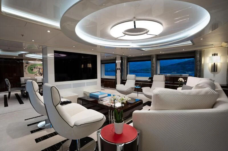 a room with a large screen and a table with chairs and a television aboard ALFA G Yacht for Sale