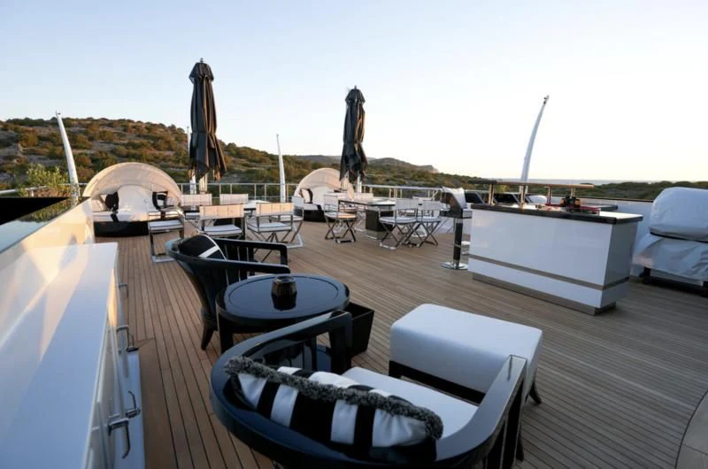 a deck with a table and chairs on it aboard ALFA G Yacht for Sale
