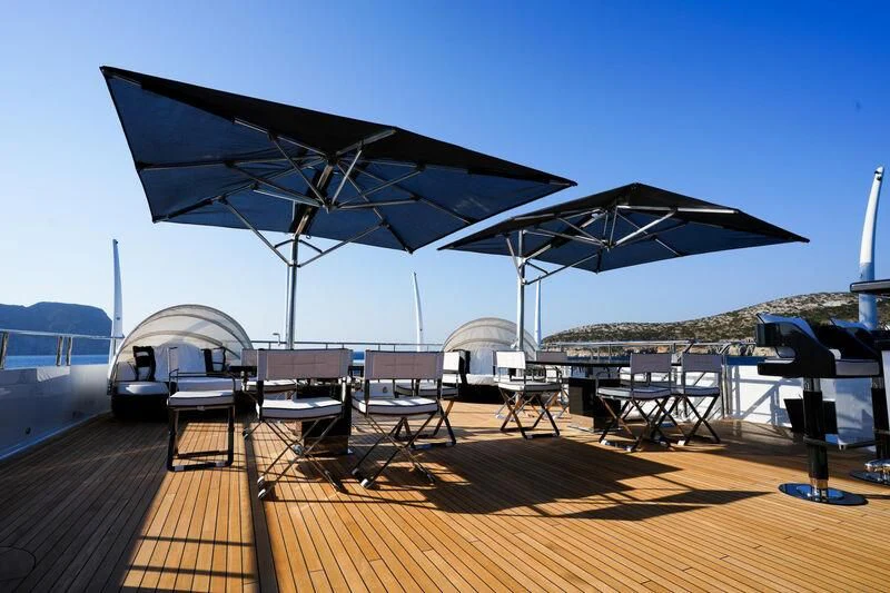 a deck with a large fan and chairs on it aboard ALFA G Yacht for Sale