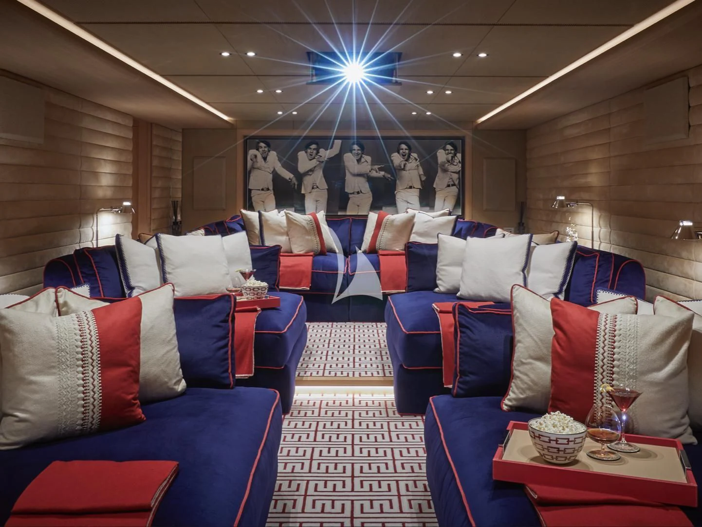 a room with a blue couch and a blue chair with red pillows aboard IJE Yacht for Sale