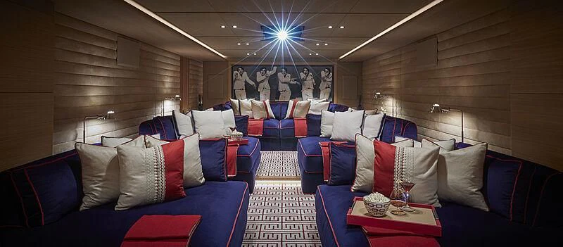 a room with a couch and a table with chairs and a fan aboard IJE Yacht for Sale