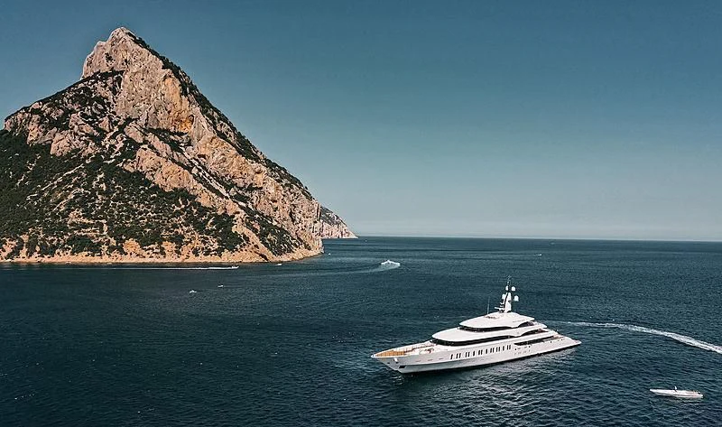 a boat sailing in the water with Roques de Anaga in the background aboard IJE Yacht for Sale