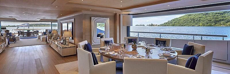 a large room with a table and chairs aboard IJE Yacht for Sale