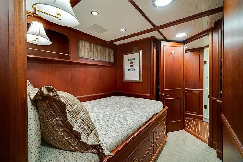 a bedroom with a bed and a wood door aboard NIRVANA Yacht for Sale