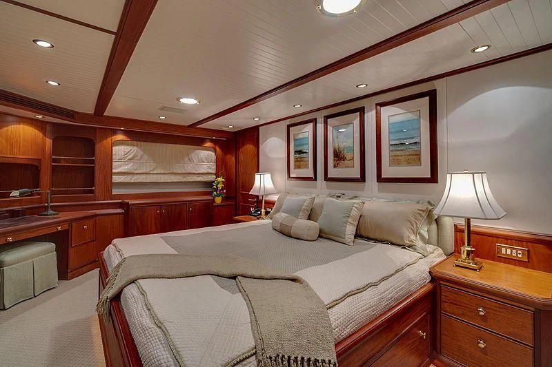 a bedroom with a bed and a desk aboard NIRVANA Yacht for Sale