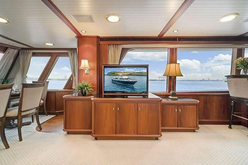 a room with a tv and a table and chairs aboard NIRVANA Yacht for Sale