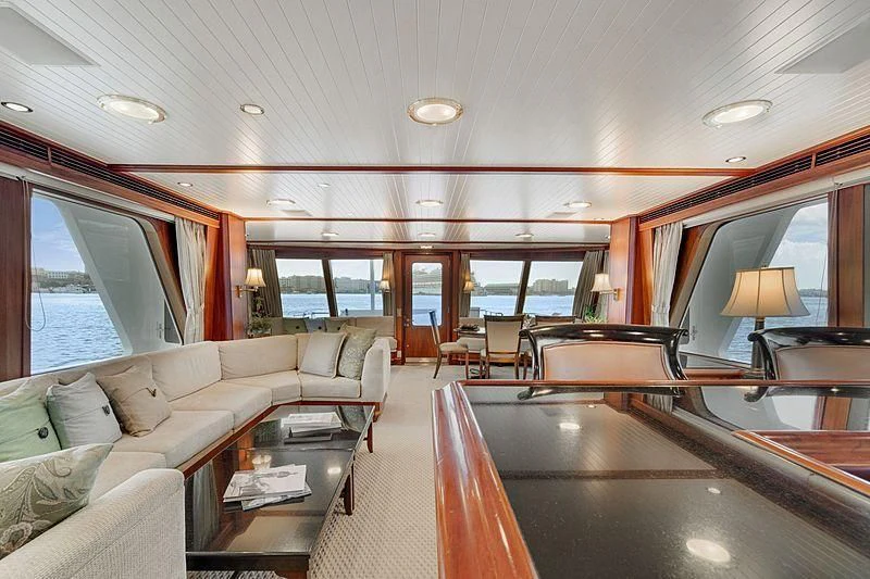 a living room with a large table and couches aboard NIRVANA Yacht for Sale