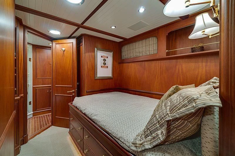 a bedroom with a bed and a wood wall aboard NIRVANA Yacht for Sale
