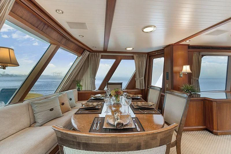 a dining table in a living room aboard NIRVANA Yacht for Sale