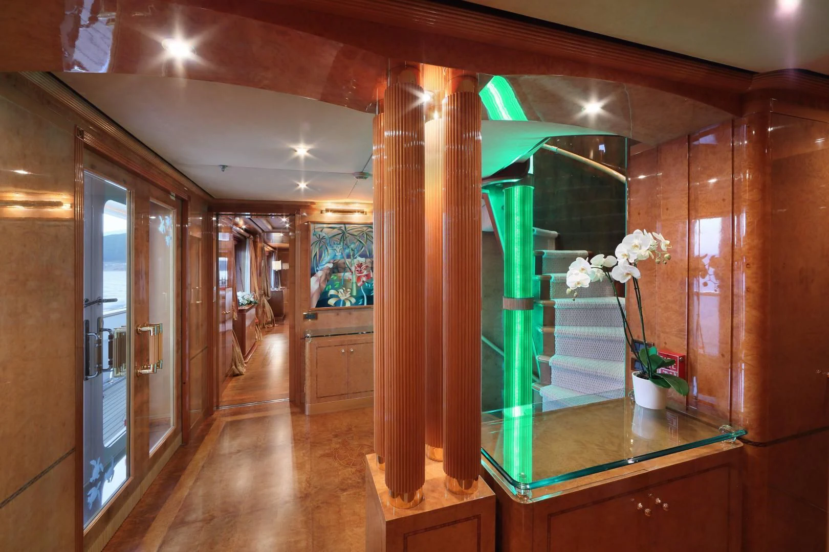 a room with a wood floor and a glass display case with flowers aboard AQUA MARE Yacht for Sale
