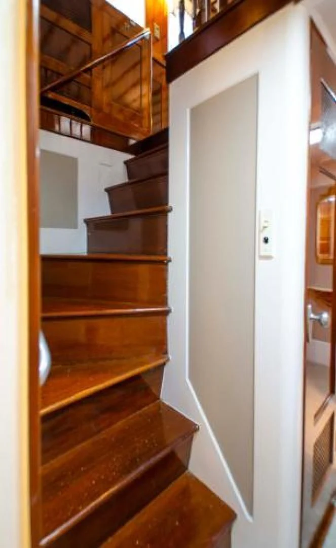 a wooden staircase with a white door aboard LIBERTY LOVE Yacht for Sale