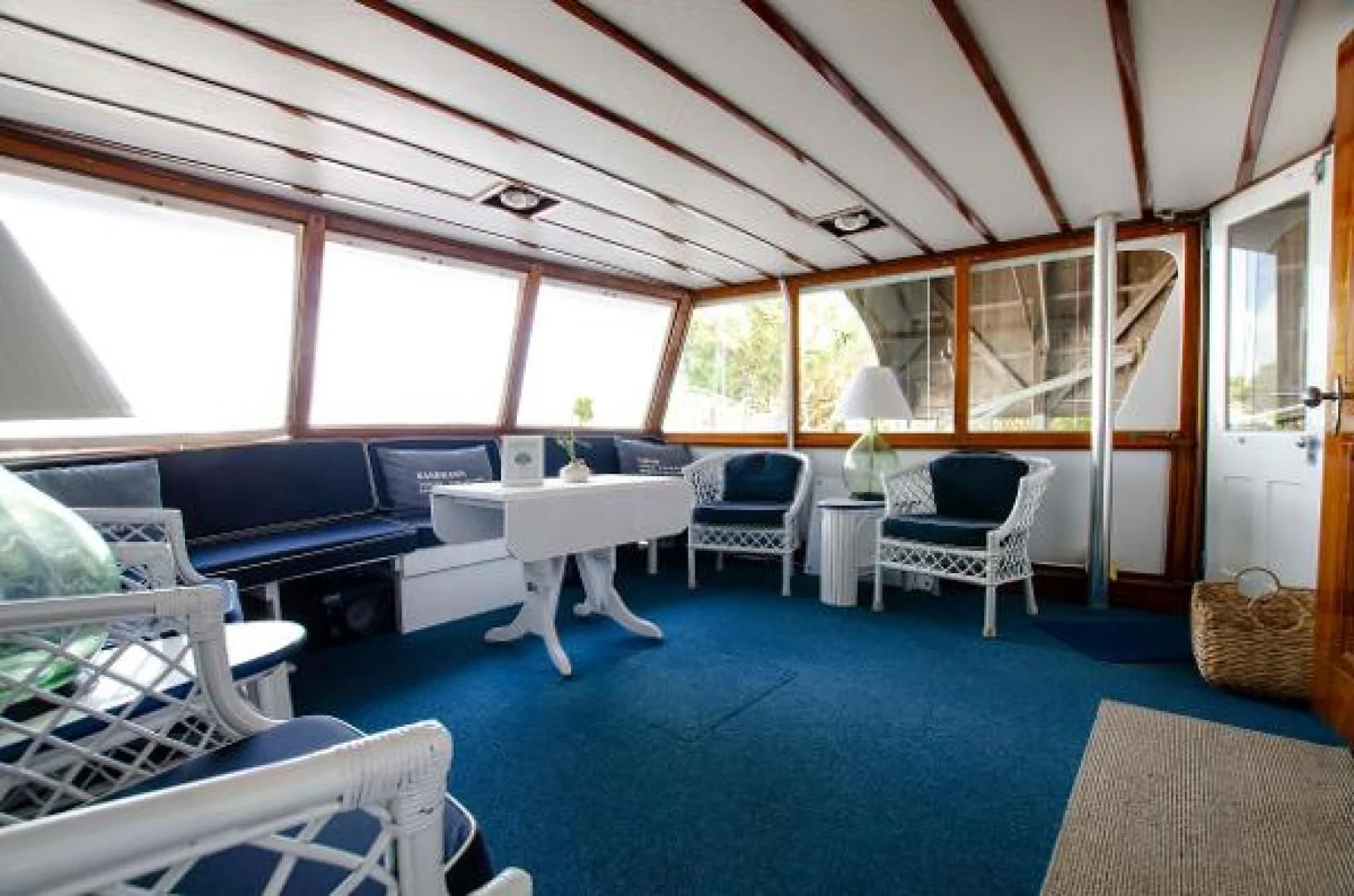 a room with a blue floor and a white table and chairs aboard LIBERTY LOVE Yacht for Sale